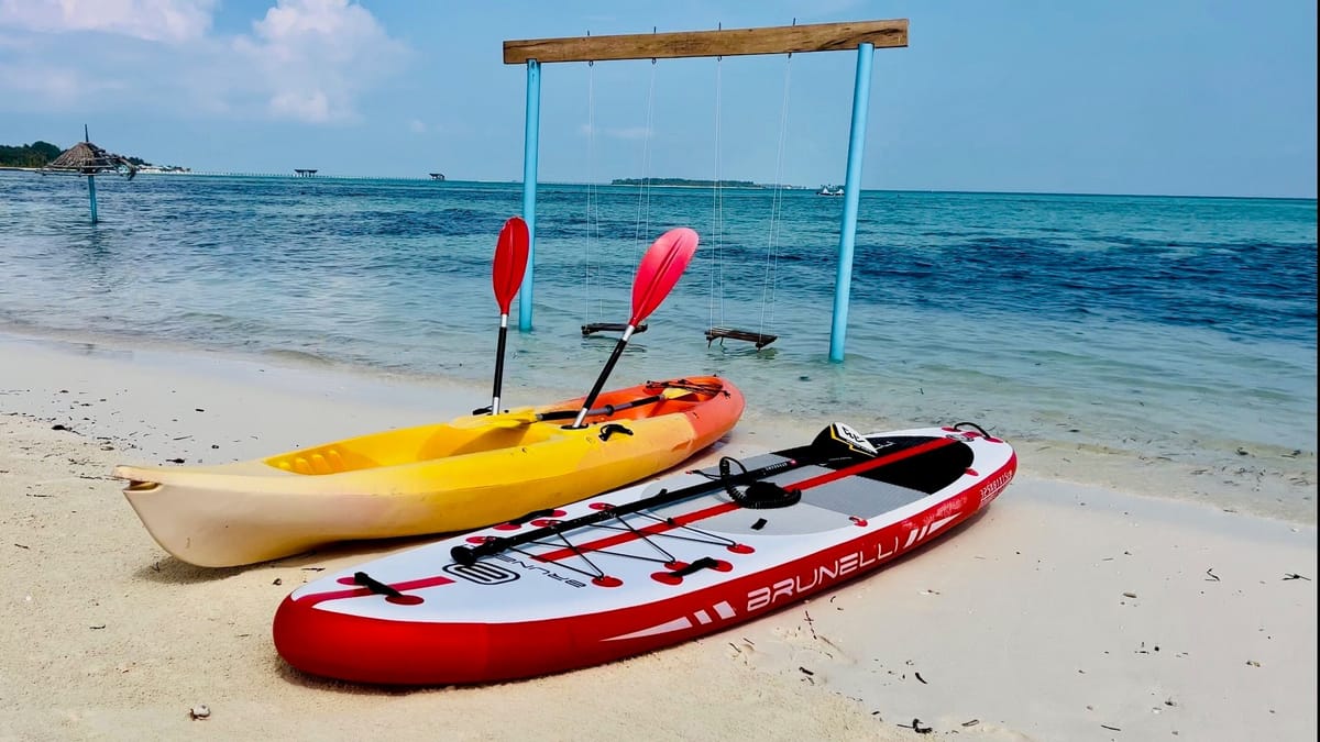 Kayaks and a stand-up paddleboard on the sand