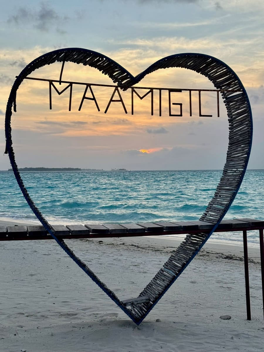 Ein Herzrahmen mit dem Schriftzug Maamigili am Strand