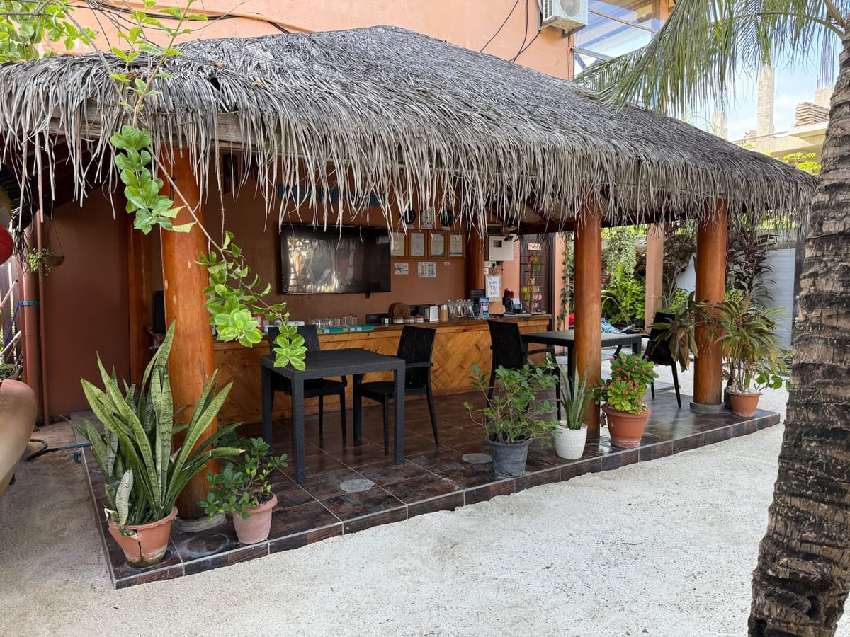 The open-sided restaurant with plants along the rail
